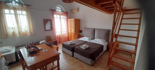 1 dormitorio con cama, mesa y escalera en Pension Selenti en Tinos Town