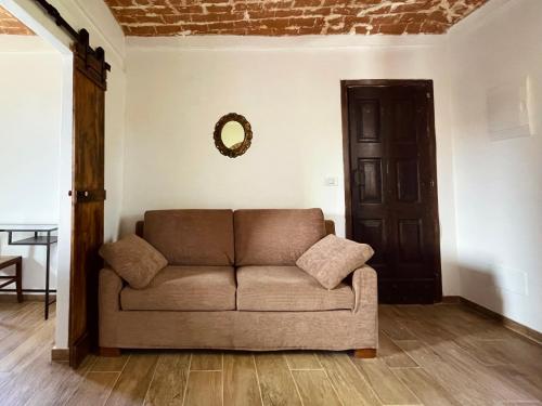 a couch in a living room with a mirror on the wall at Cascina Il Girasole Rosso in Cortazzone