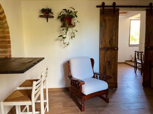 a living room with a chair and a table at Cascina Il Girasole Rosso in Cortazzone
