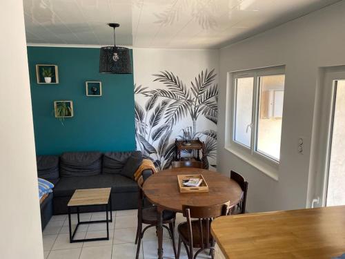 un salon avec un canapé et une table dans l'établissement Maison au calme, à Saint-Nazaire-sur-Charente