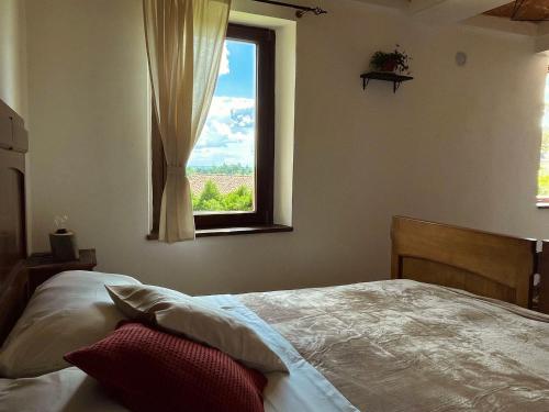 a bedroom with a bed and a window at Cascina Il Girasole Rosso in Cortazzone