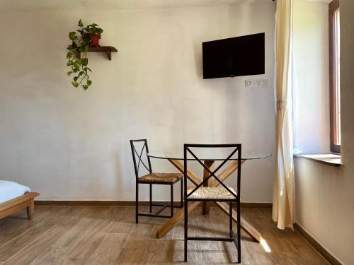 a dining room with a glass table and two chairs at Cascina Il Girasole Rosso in Cortazzone