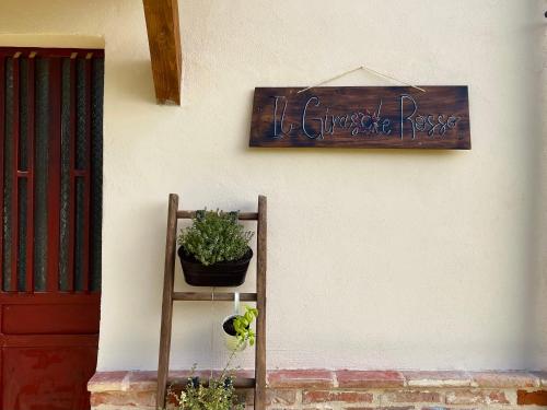 a sign on the side of a building with a plant at Cascina Il Girasole Rosso in Cortazzone