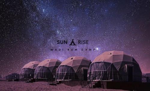 um grupo de tendas sob um céu estrelado em Sunrise Wadi Rum Camp em Wadi Rum