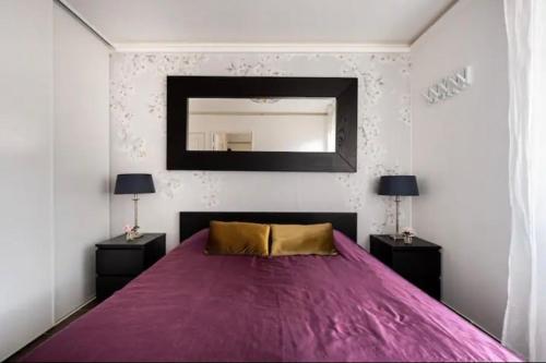 Un dormitorio con una gran cama púrpura con espejo en Carpe Diem, en Beaulieu-sur-Mer