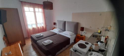 a bedroom with a bed and a bathroom with a sink at Pension Selenti in Tinos Town