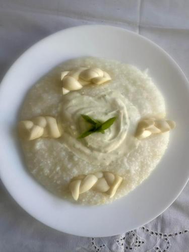 a white bowl of soup with food in it at Discover Kinchkha in Satsiskvilo