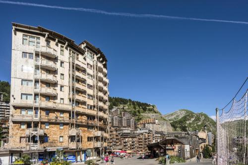 un grand immeuble d'appartements dans une ville avec une montagne dans l'établissement Résidence Les Fontaines Blanches - maeva Home - Appartement 2 Pièces 5 Personnes - Confort MAE-7312, à Morzine