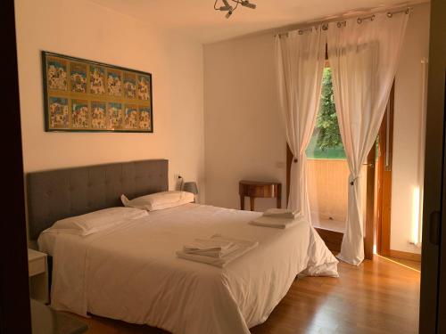 a bedroom with a white bed and a window at Residence Alice in Altavilla Vicentina