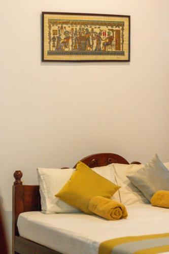 a bedroom with a bed with a picture on the wall at Xotic Resort in Kurunegala