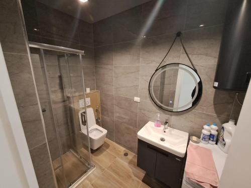a bathroom with a shower and a sink and a toilet at Gjoni's Apartment Kune Shengjin in Lezhë