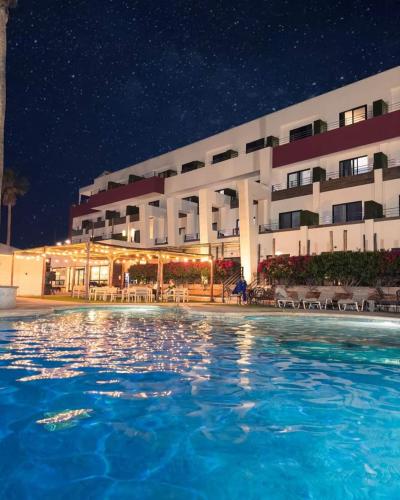 a pool in front of a hotel at night at Sawari Hotel in San Carlos