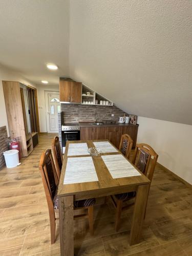 a dining room with a wooden table and chairs at SAN in Vrdnik