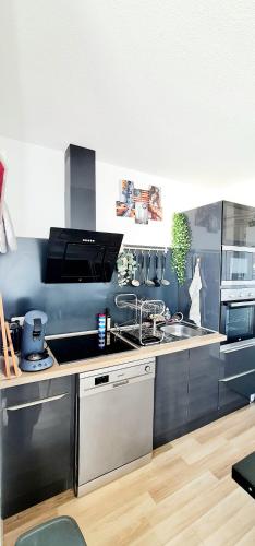une cuisine avec un évier et une cuisinière dans l'établissement Appartement Standing 110m2 lumineux, Clim, balcons, à Perpignan