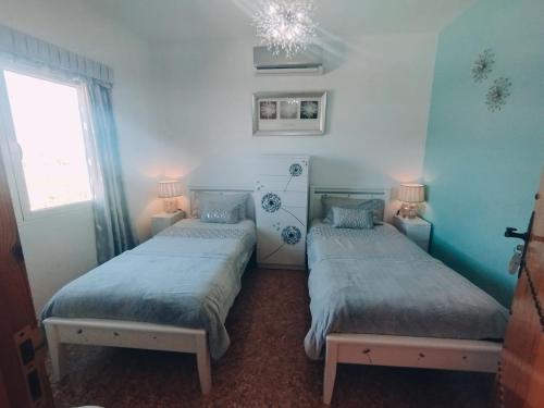 two twin beds in a room with a window at Casa rural Bodega Dorada in Cehegín