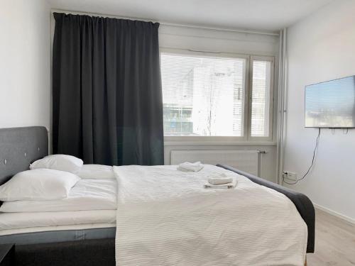 1 dormitorio con 1 cama grande y ventana en Travel Center Studio, en Pori