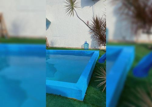 two pictures of a blue swimming pool in the grass at Casa aconchego em Blumenau in Blumenau