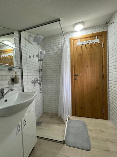 a bathroom with a sink and a wooden door at SAN in Vrdnik