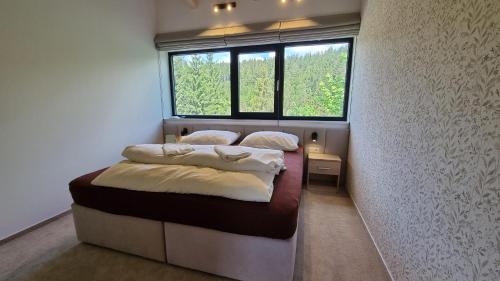 a bedroom with two beds and a window at Chalets Hrabovo in Ružomberok