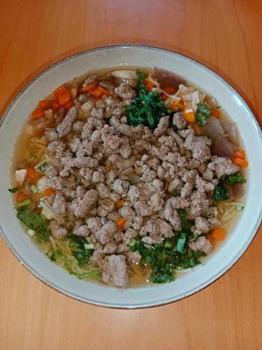 a bowl of soup with meat and vegetables on a table at Penzion Václav in Hnojní