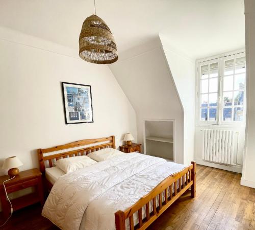 a bedroom with a large bed and a chandelier at Appartement Solidor Vue Mer in Saint Malo