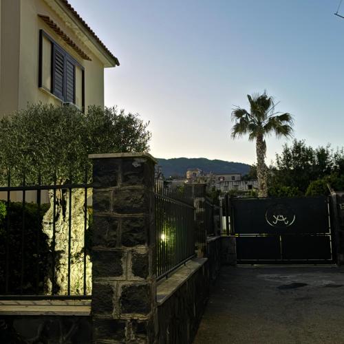a house with a fence and a palm tree at Villa Manzo relais -Pompei Vesuvius in Boscotrecase