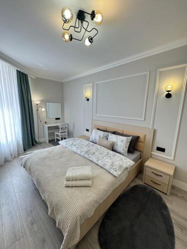 a bedroom with a large bed and a chandelier at Central Beautiful Apartment with Parking in Chişinău