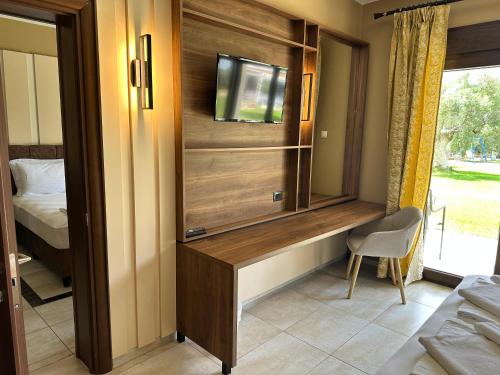 a room with a entertainment center with a television in it at Saint George Sithonia in Neos Marmaras