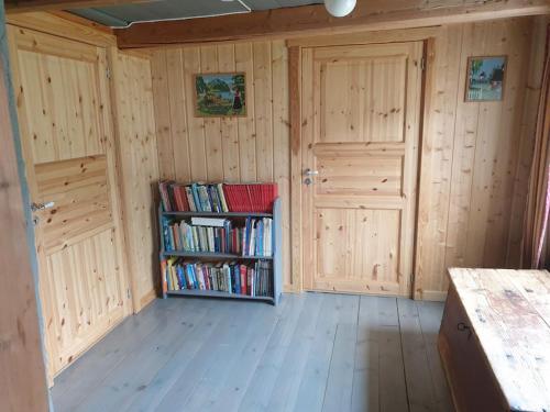 una camera con pareti in legno e una libreria con libri di Newly renovated house on a farm a Berge