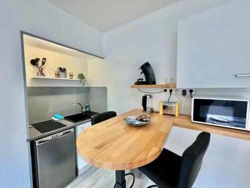 - une cuisine avec une table en bois dans une chambre dans l'établissement Studio Chamalières tout équipé - Bellevue, à Chamalières