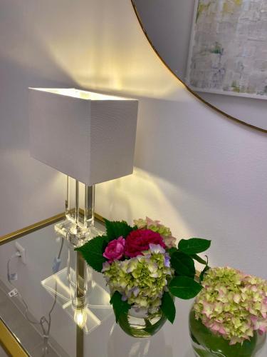 a table with two vases of flowers and a lamp at Appartement Tara in Malinska