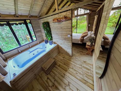 a large bathroom with a tub in a tree house at Rùstico Glamping in Santa Elena