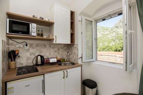 a small kitchen with a sink and a window at Apartmani Zukic in Risan