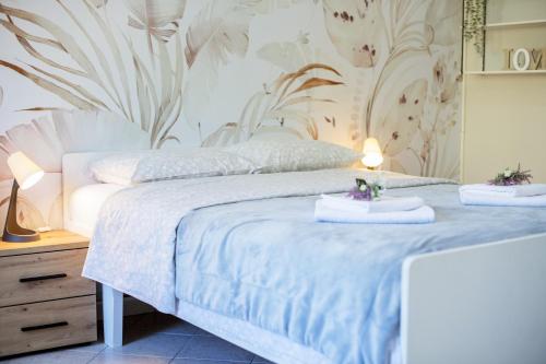 a bedroom with a white bed with a floral wallpaper at Apartmani Zukic in Risan