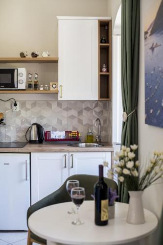 a kitchen with a table with a glass of wine at Apartmani Zukic in Risan