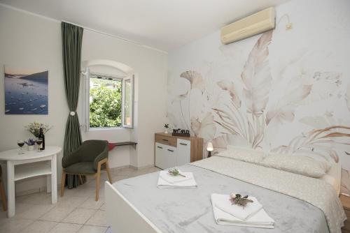 a bedroom with a bed and a desk and a chair at Apartmani Zukic in Risan
