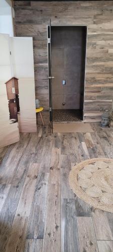 um quarto com uma porta e um tapete num piso de madeira em Le cocon de sofalia em Courcelles