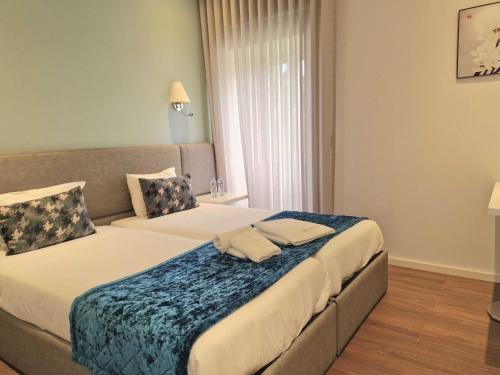 a hotel room with two beds in a room at Quinta dos Jasmins in Paços de Ferreira