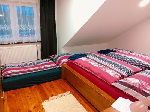 a bedroom with two beds and a window at Penzion Václav in Hnojní