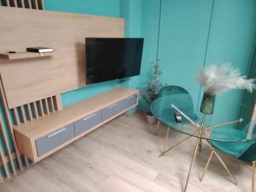 a living room with a tv and a glass table at Milan Luxury Apartaments I-Maurer Residence Târgu Mureș in Târgu-Mureş