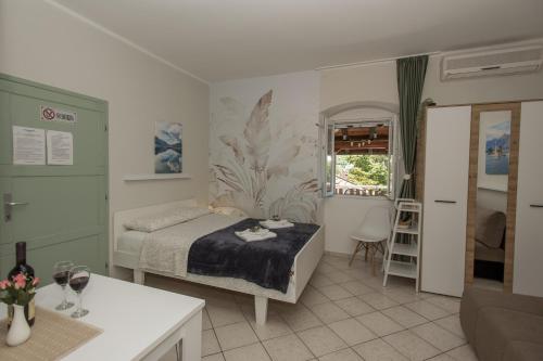 a bedroom with a bed and a table and a window at Apartmani Zukic in Risan