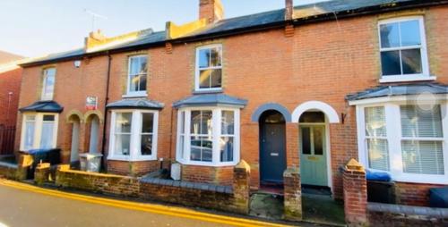 a red brick house with a blue door on a street at City center spacious bedrooms in Kent