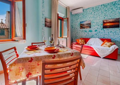 uma sala de jantar com uma mesa e cadeiras e uma cama em Casa Kira em Livorno
