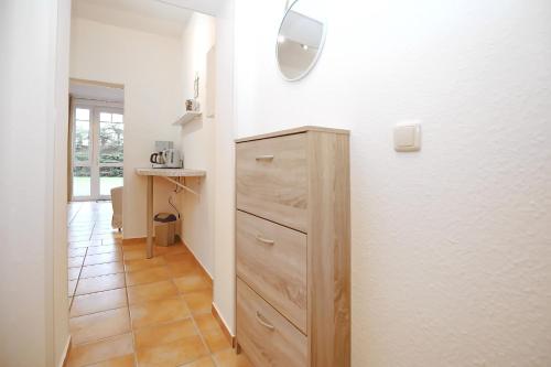 a kitchen with a wooden dresser in a room at Ostseeliebe - Sünnenkieker WE7, Beckerwitz in Beckerwitz