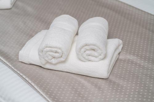 twee opgerolde handdoeken zittend op een bed bij "Golden Sky"Rooftop Pool Villa in Vodice