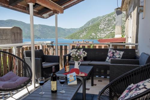 une terrasse avec une table et des bouteilles de vin. dans l'établissement Apartmani Zukic, à Risan