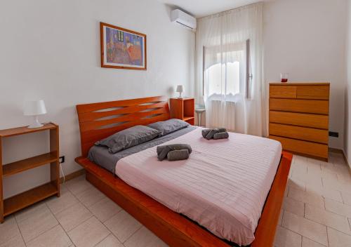 um quarto com uma cama grande com duas almofadas em Casa Kira em Livorno