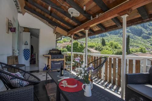 a living room with a table and chairs on a balcony at Apartmani Zukic in Risan