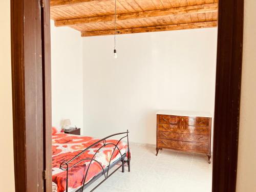 a bedroom with a bed and a dresser at Casa Lubiana in Carbonia