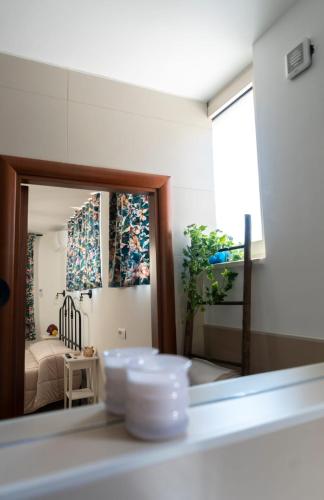 a mirror reflecting a bedroom with a bed in a room at Stanze di Puglia in Sannicandro di Bari